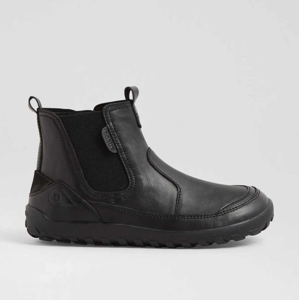 A product listing screenshot for a pair of black children's Chelsea-style boots on the BOXBUX website. The main product photo shows a single black ankle boot on a light gray background, with smaller thumbnail views of the same boot along the left side.